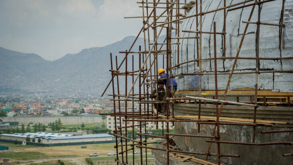 KABUL, AFGHANISTAN - May 21: Men work on scaffolding on the domed roof as Afghan workers rebuild the iconic Darulaman Palace, after decades in which its ruins were a reminder of constant conflict, on May 21, 2019, in Kabul, Afghanistan (Photo by Scott Peterson/Getty Images)