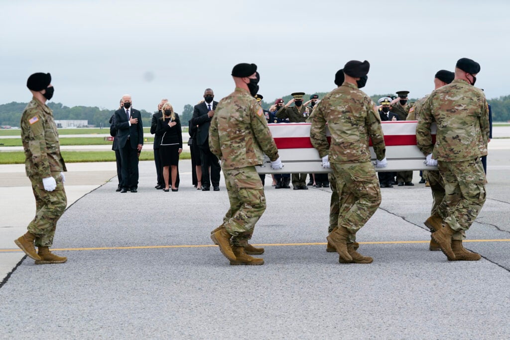 President Joe Biden, first lady Jill Biden and Secretary of Defense Lloyd Austin watch as a carry team moves a transfer case containing the remains of Army Staff Sgt. Ryan C. Knauss, 23, of Corryton, Tenn., Sunday, Aug. 29, 2021, at Dover Air Force Base, Del. Biden embarked on a solemn journey Sunday to honor and mourn the 13 U.S. troops killed in the suicide attack near the Kabul airport as their remains return to U.S. soil from Afghanistan. (AP Photo/Manuel Balce Ceneta)