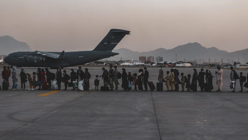 Evacuees wait to board a Boeing C-17 Globemaster III during an evacuation at Hamid Karzai International Airport, Kabul, Afghanistan, Aug. 23, 2021. (U.S. Marine Corps photo by Sgt. Isaiah Campbell)