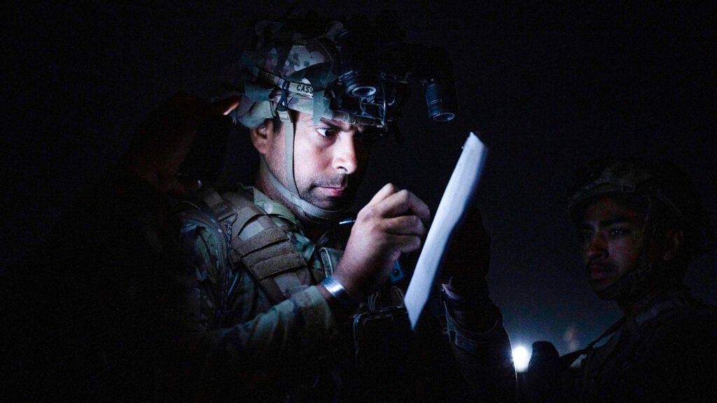 In this Aug. 30, 2021, photo provided by the U.S. Air Force, a soldier, assigned to the 82nd Airborne Division, signs a piece of paper in support of the final noncombatant evacuation operation missions at Hamid Karzai International Airport in Kabul, Afghanistan. (Senior Airman Taylor Crul/U.S. Air Force via AP)