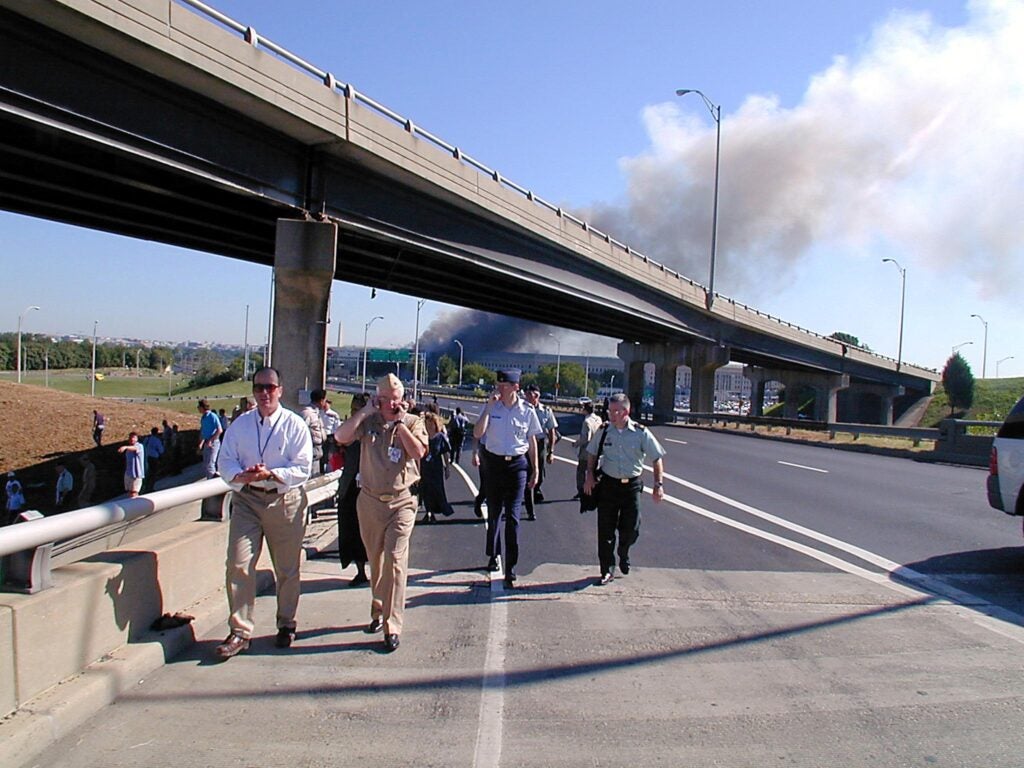 TOPSHOT - This photo released 16 September, 2001 by the US Navy shows military personnel as they walk down highway I-395 11 September, 2001 after evacuating the Pentagon because a hijacked commercial airliner crashed into the southwest corner of the building.   Hijackers took four US passenger planes hostage 11 September, crashing two of them into the World Trade Center in New York and one into the Pentagon near Washington, DC. A fourth crashed in a field near Pittsburgh, Pennsylvania.  AFP PHOTO/ US NAVY/MARK D. FARAM (Photo by - / NAVY VISUAL NEWS SERVICE / AFP) (Photo by -/NAVY VISUAL NEWS SERVICE/AFP via Getty Images)