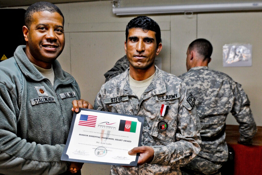 KUNAR PROVINCE, AFGHANISTAN - 2011: A handout photo shows Special Immigrant Visa applicant Ayazudin Hilal, right, receiving a Mission Essential Personnel Heart Award in 2011 in Kunar province, where Ayazudin was working as a combat translator. The image was provided to Getty Images on July 26, 2021 in Kabul, Afghanistan. Thousands of Afghans who worked for the United States government during its nearly 20-year war here now fear for their safety as the US withdraws its troops from the country. Many of these Afghans, who worked as interpreters and translators for US intelligence agencies and military branches, have applied to come to the US as part of the Special Immigrant Visa (SIV) program, with the first such group arriving in the US last month. But, for most SIV candidates, the timeline for relocation remains unknown. (Handout Photo/Getty Images)