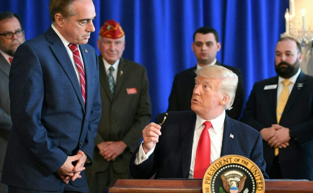 US President Donald Trump talks to Secretary of Veterans Affairs David Shulkin as he signs the Veterans Affairs Choice and Quality Employment Act on August 12, 2017, at Trump National Golf Club in Bedminster, New Jersey.

 / AFP PHOTO / JIM WATSON        (Photo credit should read JIM WATSON/AFP via Getty Images)