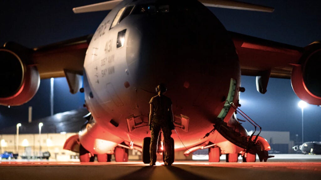 A U.S. Air Force Airman prepares to marshal a C-17 Globemaster III aircraft at Moody Air Force Base, Georgia, July 18, 2021. The Airmen were preparing for a deployment to southwest Asia in support of Operation Allies Refuge.  (Staff Sgt. Devin Boyer/U.S. Air Force)