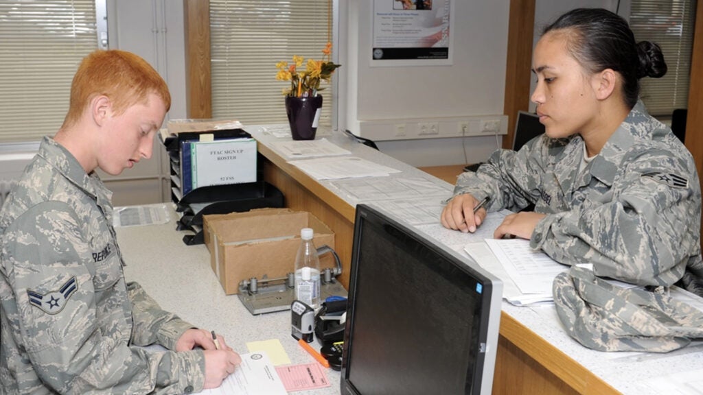 Airman 1st Class Christopher Repogle, 52nd Force Support Squadron customer service technician, helps Senior Airman Jenny Taegel, 52nd Dental Squadron, with enrolling in the defense enrollment eligibility reporting system at the Military Personnel Section at Spangdahlem Air Base, Germany, Aug. 8, 2012. (U.S. Air Force photo by Senior Airman Christopher Toon) 