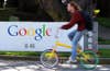 MOUNTAIN VIEW, CA - MARCH 10:  A bicyclist rides by a sign at the Google headquarters March 10, 2010 in Mountain View, California. Google announced today that they are adding bicycle routes to their popular Google Maps and is available in 150 U.S. cities. (Photo by Justin Sullivan/Getty Images)