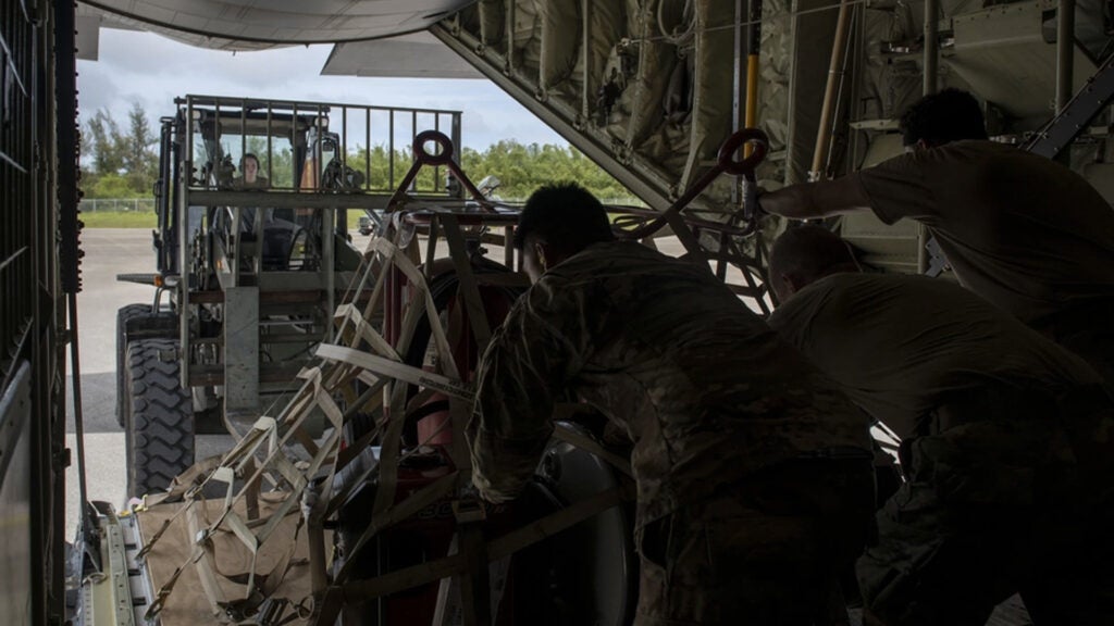 U.S. Air Force Airmen assigned to the 36th Airlift Squadron and 36th Contingency Response Group unload equipment from a C-130J Super Hercules July 25, 2021, at Tinian International Airport, Tinian, during Pacific Iron 2021. (U.S. Air Force photo by Senior Airman Hannah Bean)
