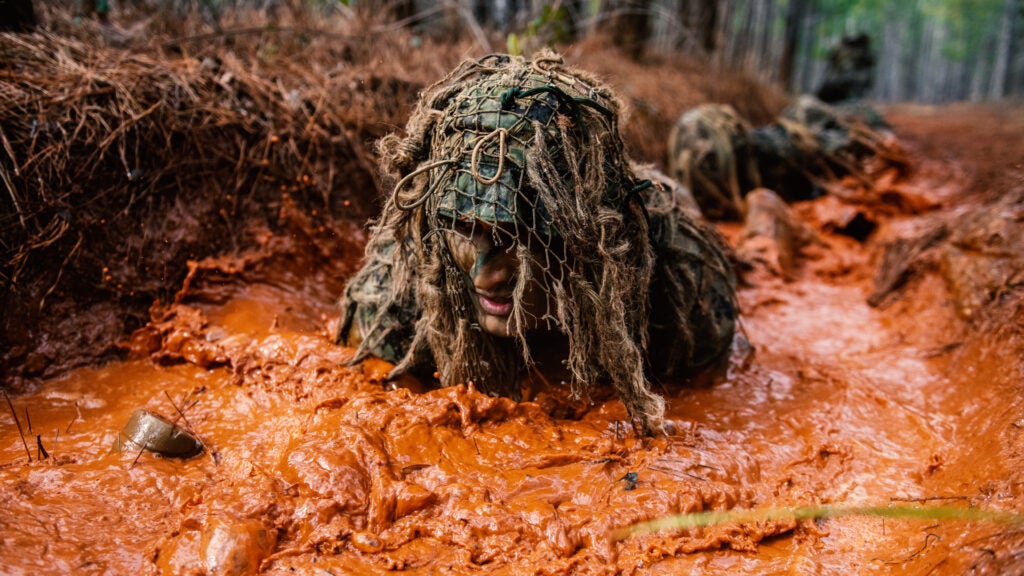 In Week 3 of U.S. Army Sniper School, 35 students participate in the ghillie wash, which is designed to test the strength and durability of the suits as well as weather them. Sniper School students use sand, water and mud, all in an effort to perfect one of their most important tools: their camouflage. (U.S. Army photo by Patrick A. Albright, Maneuver Center of Excellence and Fort Benning Public Affairs)