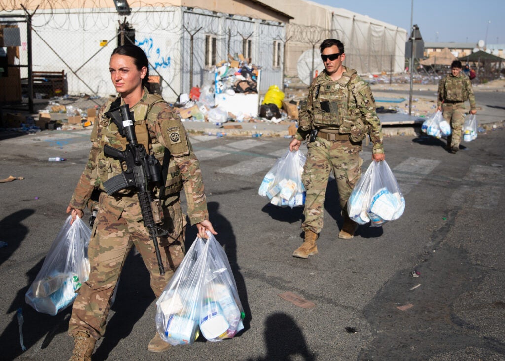 Paratroopers assigned to the 82nd Airborne Division carry bags of baby supplies to families in need during an infant needs drive at Hamid Karzai International Airport in Kabul, Afghanistan, August 26, 2021. The drive was hosted by the 82nd Abn. Div. chaplain's office who procured baby formula, diapers, juice, baby food and crackers for distribution to Afghan families who are evacuating the country. The supplies are meant to help sustain the families on their journey.(U.S. Army photos by Master Sgt. Alexander Burnett, 82nd Airborne Division)