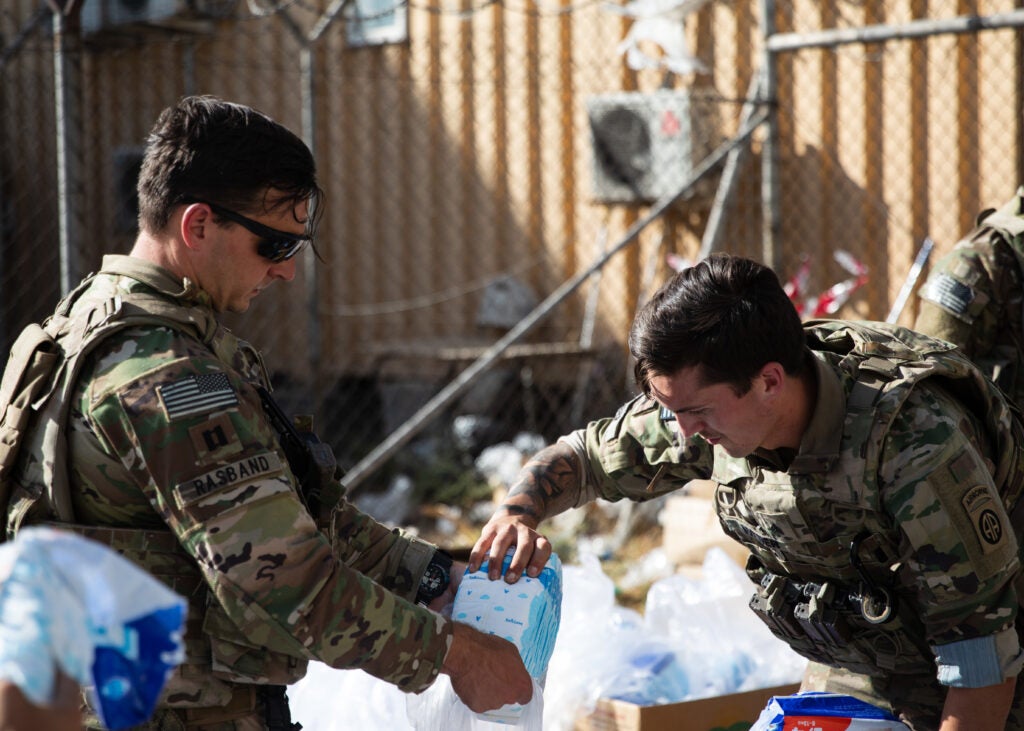 Paratroopers assigned to the 82nd Airborne Division put together bags of baby supplies during an infant needs drive at Hamid Karzai International Airport in Kabul, Afghanistan, August 26, 2021. The drive was hosted by the 82nd Abn. Div. chaplain's office who procured baby formula, diapers, juice, baby food and crackers for distribution to Afghan families who are evacuating the country. The supplies are meant to help sustain the families on their journey.(U.S. Army photos by Master Sgt. Alexander Burnett, 82nd Airborne Division)