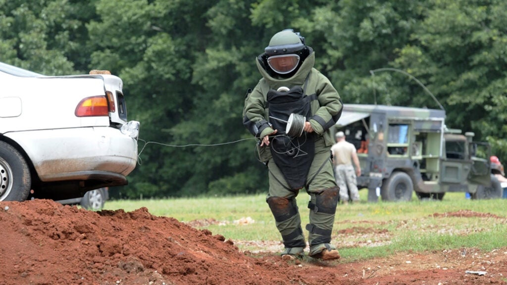 A member of the 202nd Explosive Ordnance Disposal Company, 201st Regional Support Group, runs detonation cord from the trunk of a vehicle with a suspected IED during a scenario on the second day of the Ravens Challenge VIII, a national-level interoperability exercise with multiple state and federal agencies hosted by the Bureau of Alcohol, Tobacco and Firearms, June 28, 2014. (Georgia National Guard photo by Sgt. Chris Stephens)