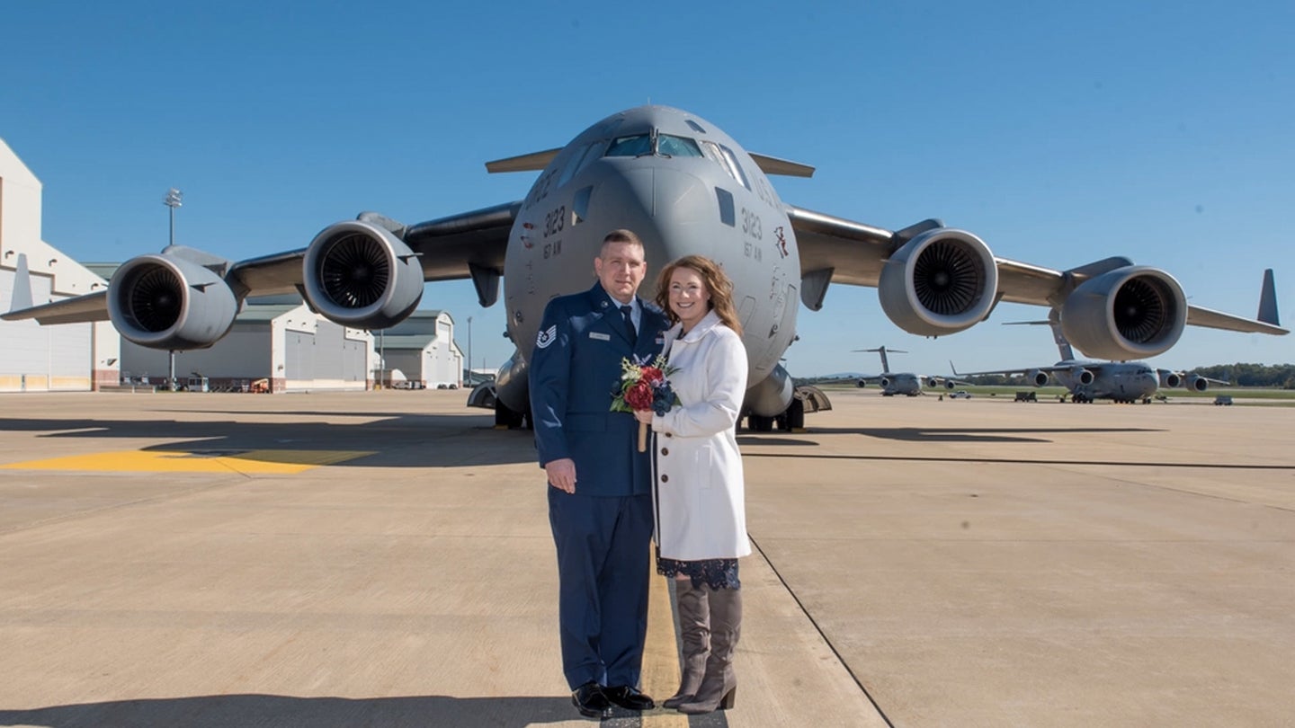U.S. Air Force Tech. Sgt. Johnathen Guzik and his wife Angela pose in front of a C-17 Globemaster III aircraft after their wedding ceremony which took place inside the cargo area of the aircraft, Oct. 19, 2021. Tech. Sgt. Guzik is an aircraft metals technician for the 167th Maintenance Group. (U.S. Air National Guard photo by Senior Master Sgt. Emily Beightol-Deyerle)