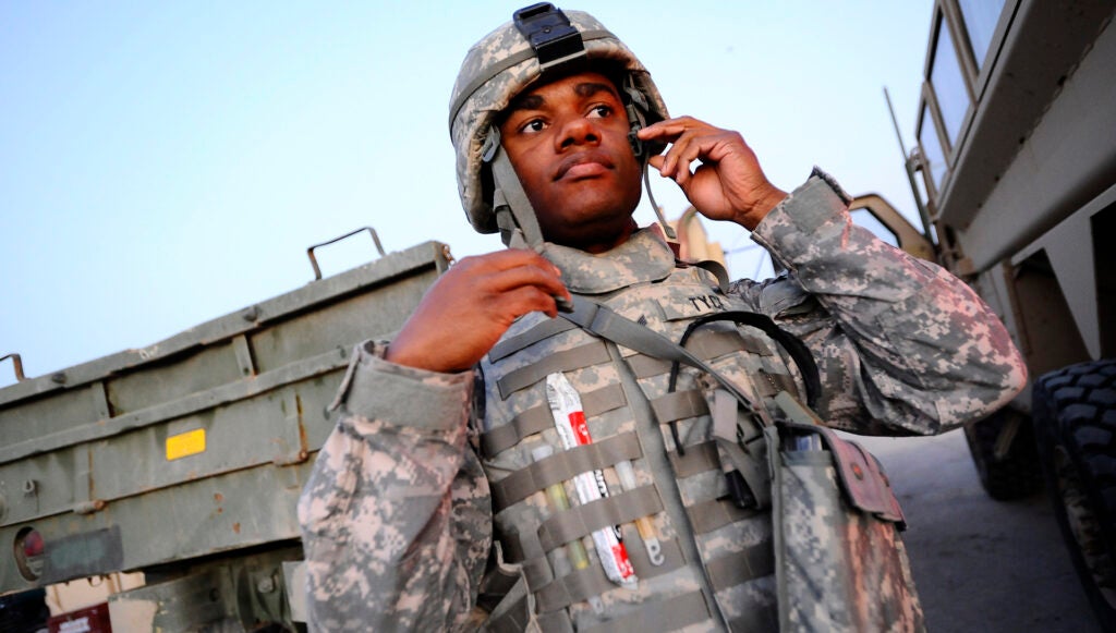 An airman dons his individual body armor at Joint Base Balad, Iraq, before leaving the base on an outside-the-wire mission. (Photo by Senior Airman Jason Epley.)