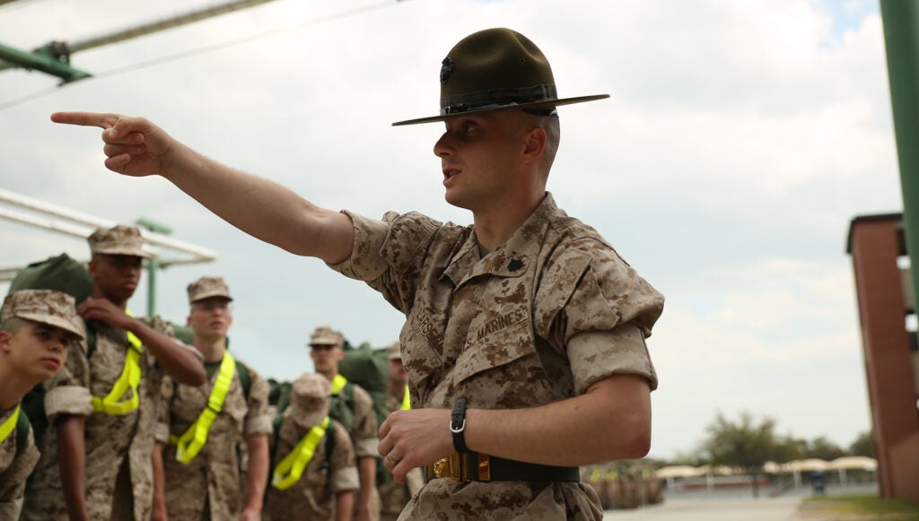 Drill instructor Sgt. Chris Larsen directs new recruits of Bravo Company, 1st Recruit Training Battalion, to enter their barracks March 25, 2014, on Parris Island, S.C. Drill instructors like Larsen, a 27-year-old from Lyons, Kan., guide new recruits through in-processing and teach them how to act before they begin the official training curriculum. If the young men hope to be successful in the following three months, they must quickly adapt to the standards of recruit training. Bravo Company is scheduled to graduate June 20, 2014. Parris Island has been the site of Marine Corps recruit training since Nov. 1, 1915. Today, approximately 20,000 recruits come to Parris Island annually for the chance to become United States Marines by enduring 13 weeks of rigorous, transformative training. Parris Island is home to entry-level enlisted training for 50 percent of males and 100 percent of females in the Marine Corps. (Photo by Cpl. Octavia Davis)