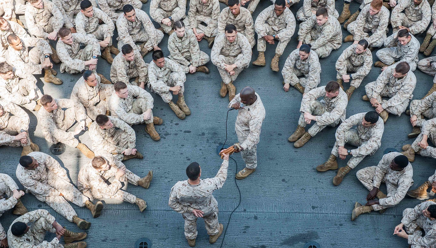 A sergeant major hands an honorary bull whip to a Marine during an all hands call on the flight deck of the amphibious assault ship USS America (U.S. Navy photo by Mass Communication Specialist 2nd Class Alexander A. Ventura II/Released)