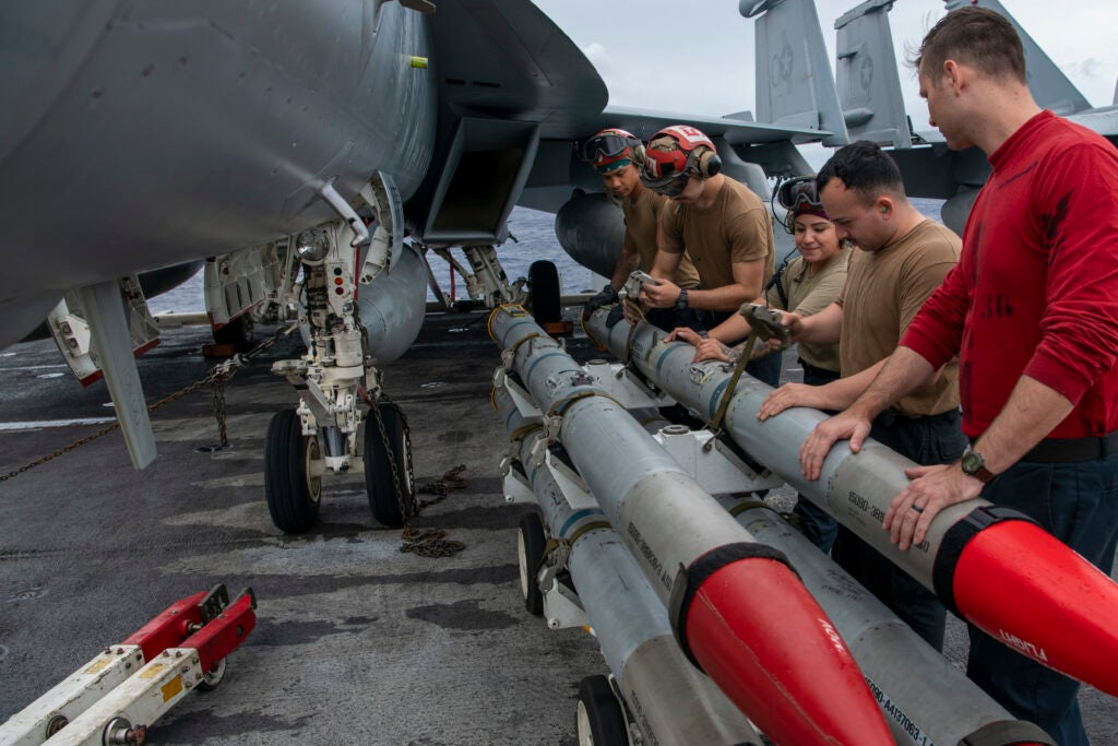 211119-N-TY650-1001 PHILIPPINE SEA (Nov. 19, 2021) Sailors load ordnance onto an EA-18A Growler, assigned to the “Gauntlets” of Electronic Attack Squadron (VAW) 136, on the flight deck of Nimitz-class aircraft carrier USS Carl Vinson (CVN 70) Nov. 19, 2021. U.S. forces with 1st Marine Aircraft Wing and the U.S. Navy’s 7th Fleet are conducting a large-scale joint rehearsal of tactics and simulated strikes on naval targets off the coast of Okinawa, Japan. Carl Vinson Carrier Strike Group is on a scheduled deployment in the U.S. 7th Fleet area of operations to enhance interoperability through alliances and partnerships while serving as a ready-response force in support of a free and open Indo-Pacific region. (U.S. Navy photo by Mass Communication Specialist 2nd Class Jonteil L. Johnson)
