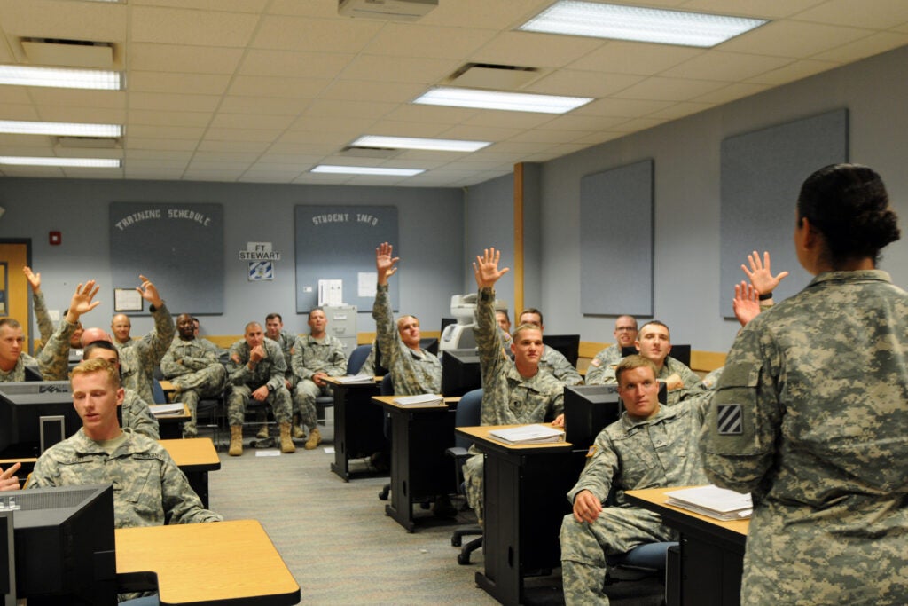 "Cottonbalers" from 3rd Battalion, 7th Infantry Regiment, 4th Infantry Brigade Combat Team, 3rd Infantry Division, raise their hands to answer a vocabulary question from Spc. Assal Ravandi, an automated logistics specialist with Headquarters and Headquarters Company, 3rd Bn., 7th Inf. Regt., Aug. 30, in a classroom on Fort Stewart, Ga. The vocabulary competition was part of a presentation the Soldiers created for battalion leadership to show their grasp of the Dari language after having spent five weeks in an intensive language training program created by Ravandi, a native Dari speaker.