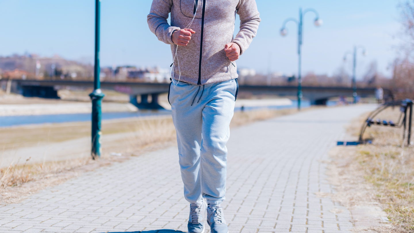 An athlete running in sweatpants.