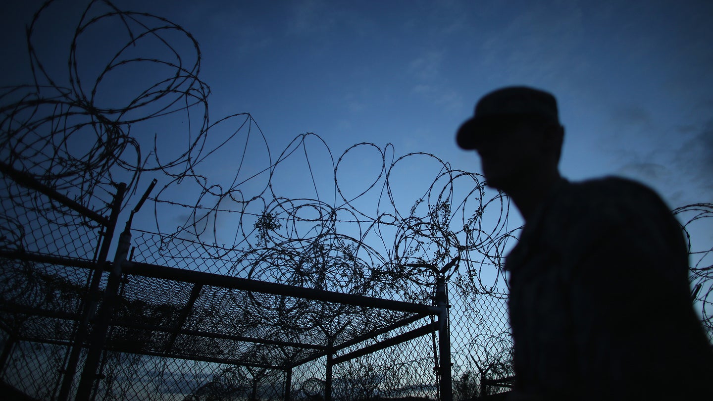 GUANTANAMO BAY, CUBA - JUNE 27:  (EDITORS NOTE: Image has been reviewed by the U.S. Military prior to transmission.) A Public Affairs Officer escorts media through the currently closed Camp X-Ray which was the first detention facility to hold 'enemy combatants' at the U.S. Naval Station on June 27, 2013 in Guantanamo Bay, Cuba.The U.S. Naval Station at Guantanamo Bay, houses the American detention center for 'enemy combatants'. President Barack Obama has recently spoken again about closing the prison which has been used to hold prisoners from the invasion of Afghanistan and the war on terror since early 2002.  (Photo by Joe Raedle/Getty Images)