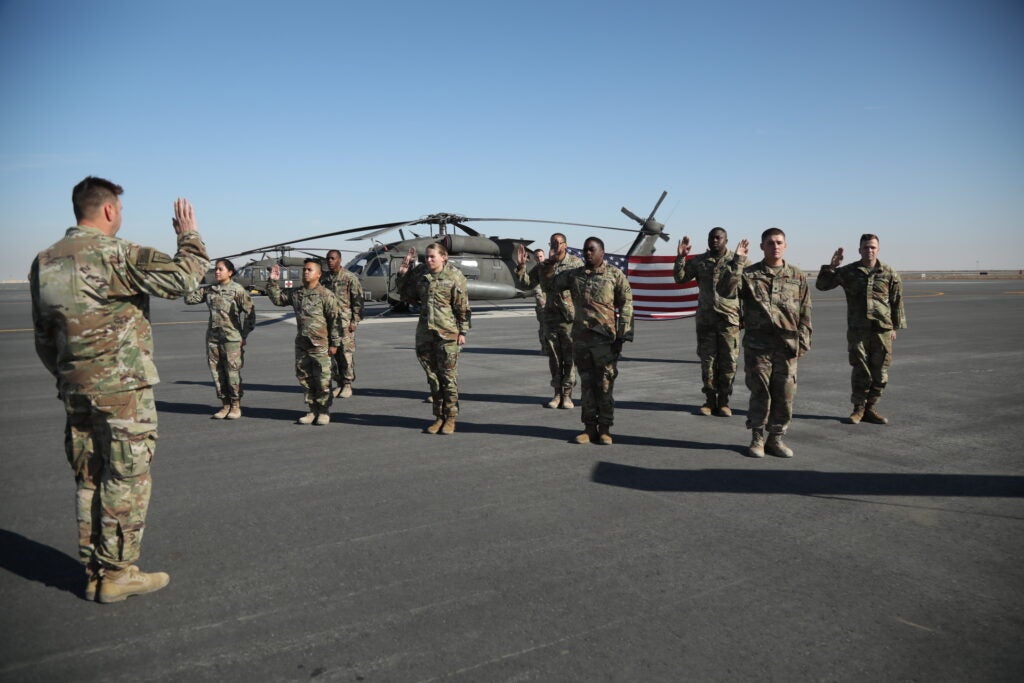 U.S. Army Soldiers, assigned to the 3rd Division Sustainment Brigade, participated in a re-enlistment ceremony at Camp Buehring, Kuwait Dec. 12, 2021. Before re-enlisting 3DSB Soldiers were given the opportunity to ride in a Boeing CH-47 Chinook as a reward for re-enlisting. (U.S. Army Photo by Cpl. Aaliyah Craven)