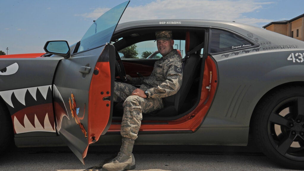 U.S. Air Force Tech. Sgt. Stephen Strong, 315th Training Squadron instructor, leans back in the driver seat of his Chevy Camaro at Goodfellow Air Force Base, Aug. 18, 2015. Strong painted his car on his own, designing both the interior and exterior after an old WWII P-40 Warhawk. (U.S. Air Force photo by Airman Caelynn Ferguson/Released)