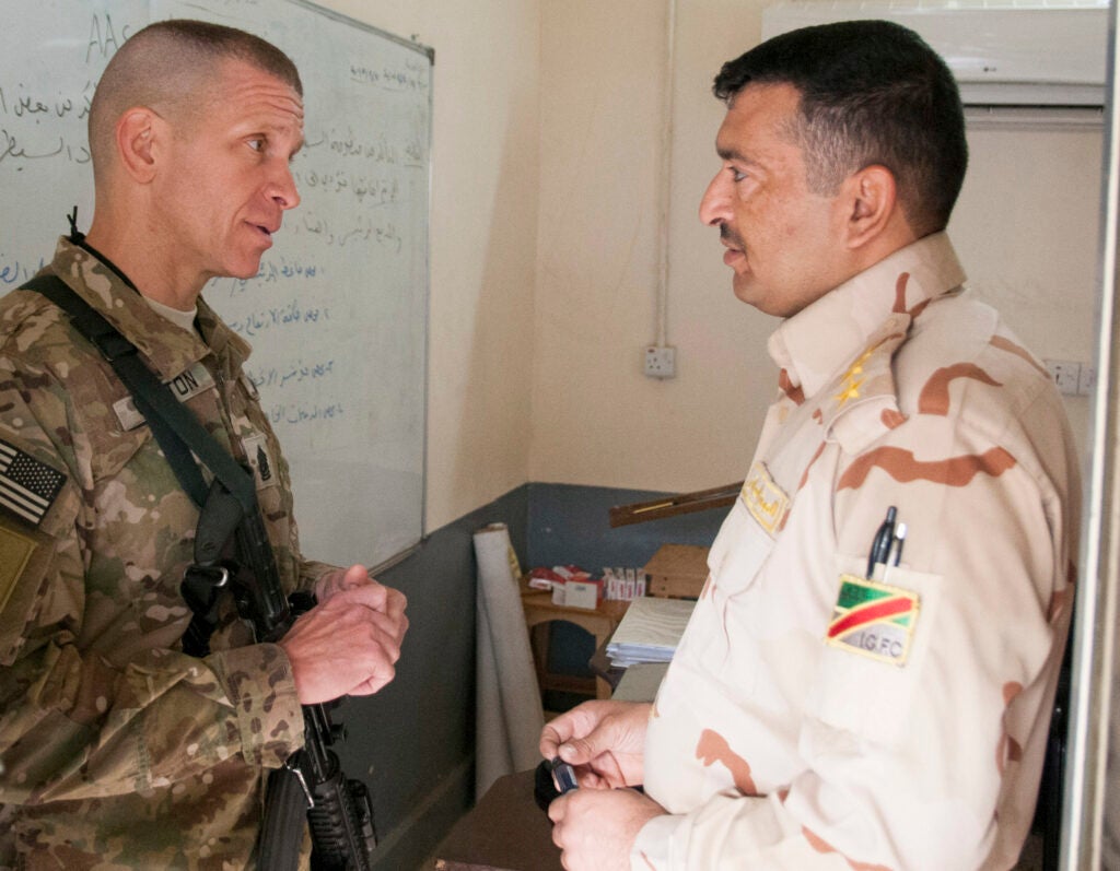 Command Sgt. Maj. Michael Grinston, center, senior noncommissioned officer of the 1st Infantry Division and Combined Joint Forces Land Component Command – Iraq, speaks with Iraqi Army Capt. Yassen Saleh Mohannad, lead tank and armor instructor with the 1st Battalion, 34th Armor Regiment of the Iraqi Army’s 9th Division, Jan. 3 at Camp Taji, Iraq. Grinston sat in on classes and inspected IA tanks during his visit to Camp Taji. (Staff Sgt. Daniel Stoutamire, 1st Inf. Div.)