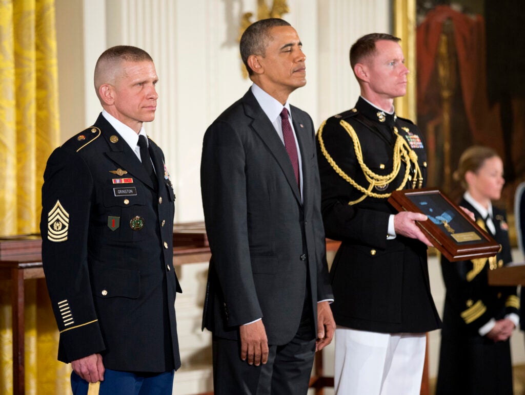 Command Sgt. Maj. Michael Grinston, left, stands with President Barack Obama before accepting the Medal of Honor on behalf of Sgt. Candelario Garcia, during a ceremony in the East Room of the White House on Tuesday, March 18, 2014, in Washington. Obama awarded 24 Army veterans the Medal of Honor for conspicuous gallantry in recognition of their valor during major combat operations in World War II, the Korean War and the Vietnam War. (AP Photo/Manuel Balce Ceneta)