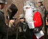 Capt. James Thomas, dressed as Santa, shakes hands with Soldiers in the motor pool of Patrol Base Assassin. Thomas serves with Headquarters and Headquarters Company, 2nd Brigade Combat Team, 1st Armored Division, Multi-National Division - Baghdad. He flew around on Christmas day with Col. Pat White, commander of the Iron Brigade, to lift Soldiers' spirits. Thomas is a native of Oskaloosa, Kan., and White is native of Apple Valley, Calif.