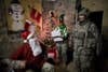 SABARI DISTRICT, AFGHANISTAN - DECEMBER 25:  A US soldier from the 101st Airborne dressed as Santa Claus hands out gifts at a combat outpost at the Sabari District Center on Christmas Day December 25, 2008 in Sabari District, Khost Province, Afghanistan.  Khost province borders the Waziristan region in Pakistan, where it is believed foreign fighters cross into Afghanistan to combat coalition forces.  (Photo by Jonathan Saruk/Getty Images)