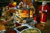 BASRA, IRAQ:  A British army soldier wearing with Santa Claus hat brings a food during a Christmas lunch in Multi-National Division (MND-SE) headquarters, at Basra International Airport, in Basra, 550kms southeast of Baghdad, 25 December 2003. AFP PHOTO/Mauricio LIMA  (Photo credit should read MAURICIO LIMA/AFP via Getty Images)