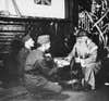 (Original Caption) England: Yanks Celebrate Christmas In England. Santa Claus (Sgt. Hiram Proutly of Baltimore) hands out packages to private Albert Weber of Pittsburgh and Corp. William Goldstein of Baltimore.