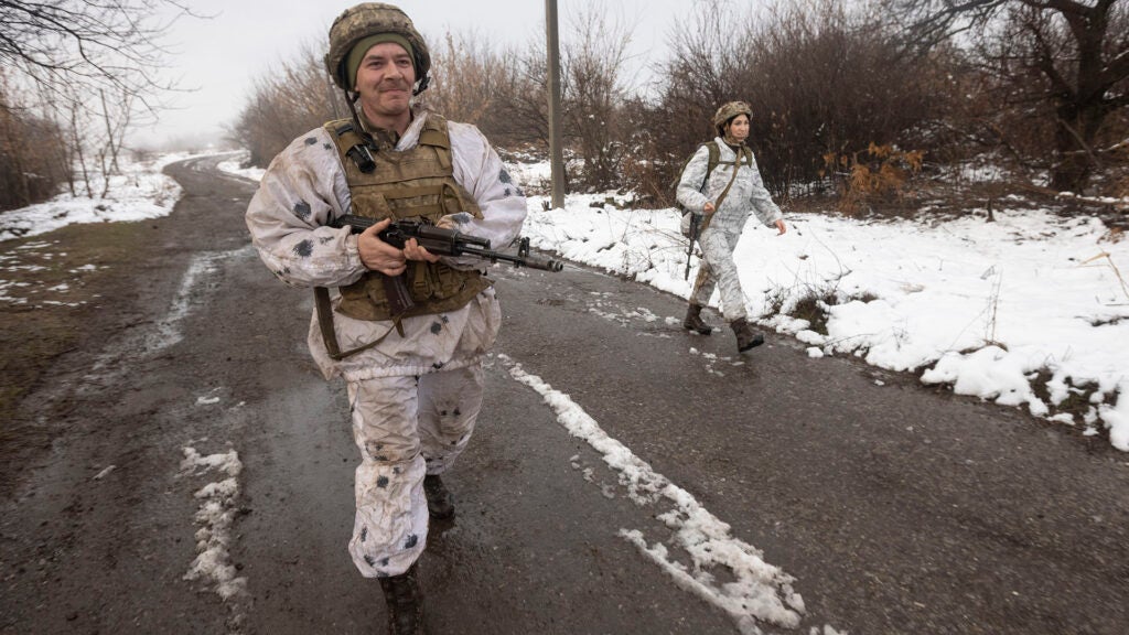 Ukrainian soldiers walks at the line of separation from pro-Russian rebels near Katerinivka, Donetsk region, Ukraine, Tuesday, Dec 7, 2021. Ukrainian authorities on Tuesday charged that Russia is sending tanks and snipers to the line of contact in war-torn eastern Ukraine to "provoke return fire," an accusation that comes amid fears that a Russian troop buildup near the Ukrainian border might indicate plans for an invasion. (AP Photo/Andriy Dubchak)