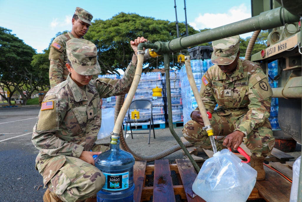 Task Force Ohana Soldiers fill containers with potable water for Aliamanu Military Reservation residents (AMR) at a water supply point at AMR on Dec. 15th, 2021 at AMR, Hawaii.Task Force Ohana Soldiers are currently providing ongoing support to the local residents of Aliamanu Military Reservation and Red Hill housing areas due to affected water supplies and concerns with Services provided to residents include the distribution of freshwater, alternate lodging, medical screening services, and identification of any other resident needs.