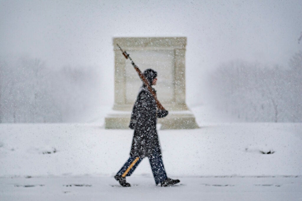 A tomb guard from the 3d U.S. Infantry Regiment (The Old Guard) walks the mat during a snow storm at the Tomb of the Unknown Soldier at Arlington National Cemetery, Arlington, Va., Jan. 3, 2022. (U.S. Army photo by Elizabeth Fraser / Arlington National Cemetery)