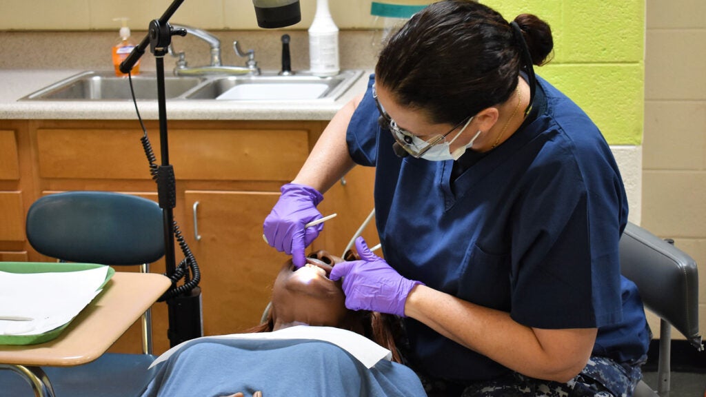 A Navy dentist performs an examination on a patient at the clinic in Warrenton, Ga., July 11, 2018. (U.S. Air Force photo by Maj. John T. Stamm)