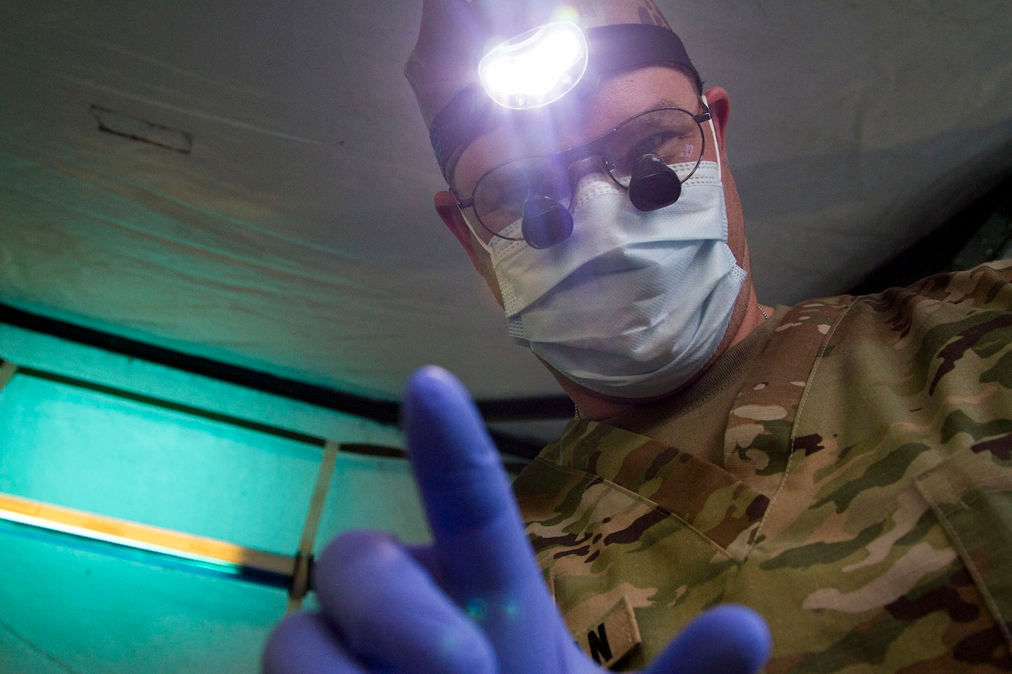 An Army dentist prepares to work on a patient as part of a medical readiness training exercise. (U.S. Army photo by. Sgt. Anshu Pandeya)