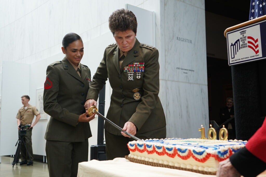 U.S. Marine Corps Cpl. Daisha Sosa, combat photographer, Office of Marine Corps Communication and Lt. Gen. Loretta “Lori” Elanor Reynolds, deputy commandant, Information, cut a cake at the opening of the exhibition Women Marines – Proudly Serving 1918-2018, at the Women in Military Service for America Memorial, Arlington, Va., Aug. 12, 2018. The exhibit chronicles the 100 years of service by women throughout the history of the Marine Corps. (U.S. Marine Corps photo by Cpl. Paul A. Ochoa)