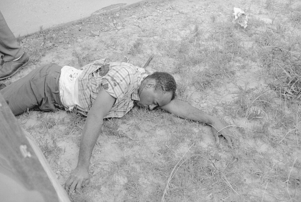 (Original Caption) Hernando, Mississippi: James Meredith, with blood streaming from his wounds, lies beside Mississippi Highway 51 after he was shot from ambush, June 6. A Memphis man, Aubrey J. Norvell, was arrested in the shooting. Meredith, not seriously wounded, was taken to a hospital in Memphis. June 6, 1966.