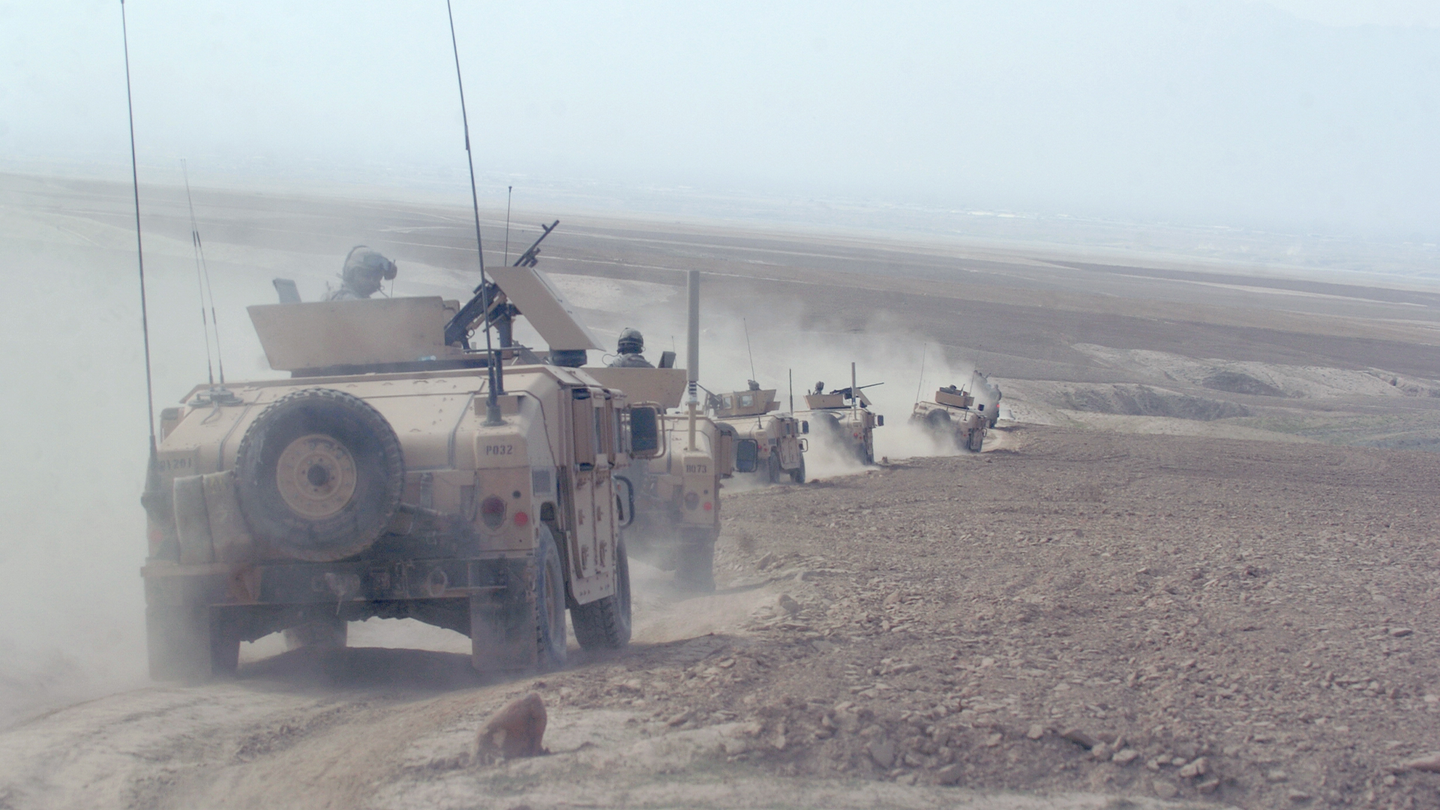 Humvees kick up dust traveling through a mine field near Gadaykhel, Kohe Safi District, Parwan province, March 12, 2008