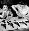 Female workers Agnes Apostle of Dauphin, Manitoba and Joyce Horne of Toronto, Ontario conduct a final assembly of a 9 mm. semi-automatic Browning Hi0Power destined for China at the John Inglis Co. munitions plant in Toronto, Canada, 1944.