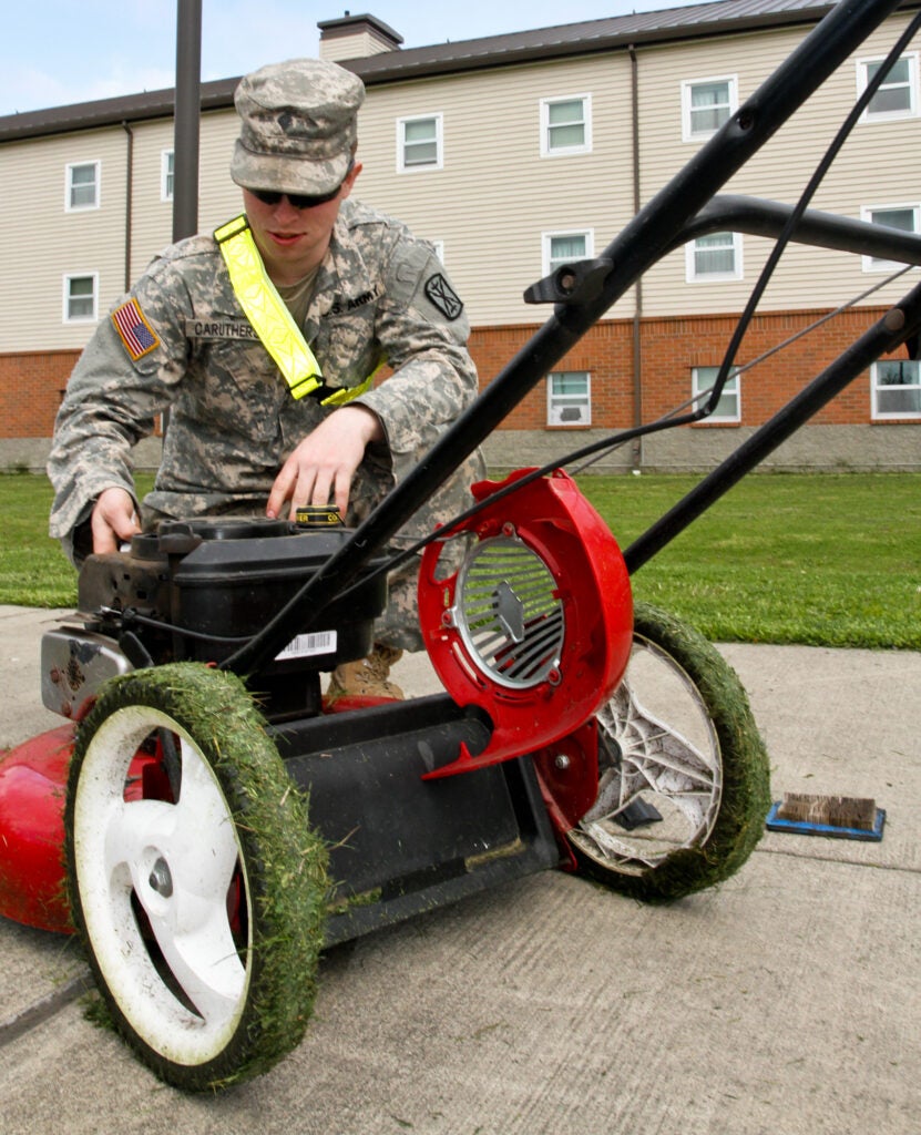 Spc. Cameron Caruthers, a Mena, Ark., native, and motor transport operator with 606th Forward Support Company, 1st Battalion, 377th Field Artillery Regiment, 17th Fires Brigade, works on a faulty lawn mower during spring cleaning at the 17th Fires Brigade barracks, April 11, 2013. 606th "Outlaw" soldiers conduct spring cleaning on their area of operations for the same reason they apply uniform and hairstyle standards daily: to maintain a professional, clean-cut appearance that promotes pride and functionality. While Caruthers doesn't live at the barracks, he's a strong believer in teamwork and didn't want the soldiers residing there to have to do all the work on their own. "I volunteered for this because single soldiers at the barracks maintain the area constantly, and I thought I should help them do that," Caruthers said. (U.S. Army photo by Spc. Nathan Goodall, 17th Fires Brigade Public Affairs)