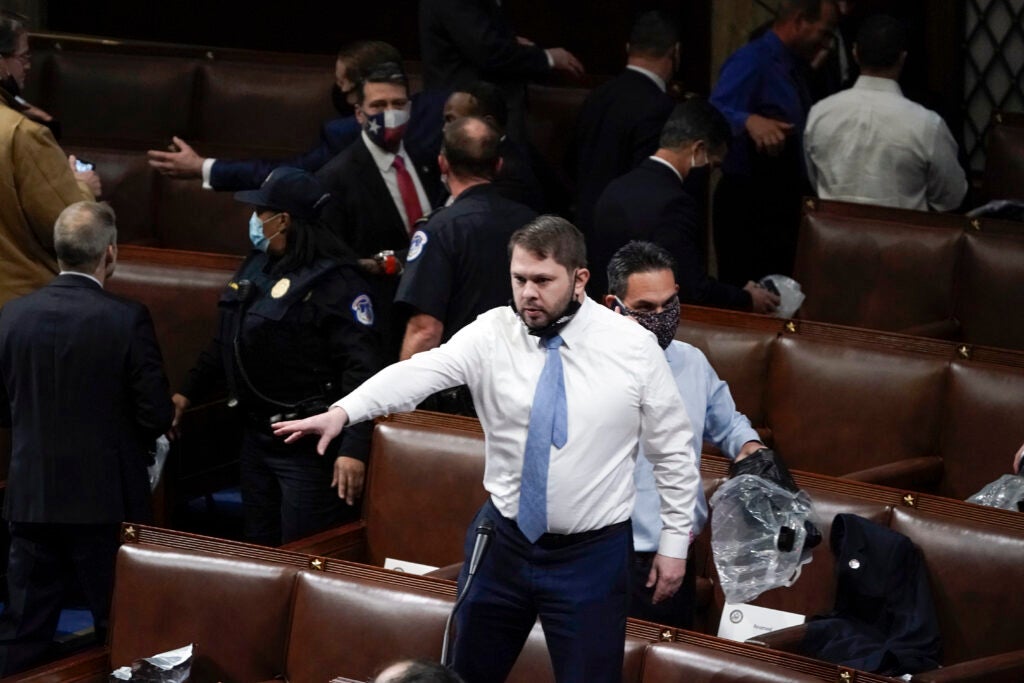 Rep. Ruben Gallego (D-AZ) stands on a chair as lawmakers prepare to evacuate the floor as rioters try to break into the House Chamber at the U.S. Capitol on Wednesday, Jan. 6, 2021, in Washington. (AP Photo/J. Scott Applewhite)