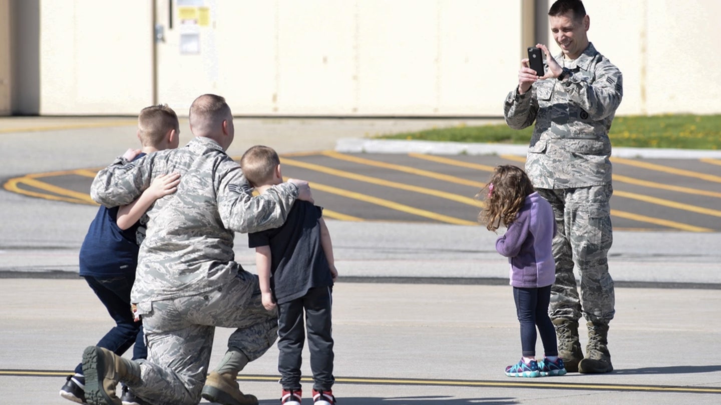 A New Jersey Air National Guard Senior Airman takes a photo of another Airman with their kids during Bring Your Child to Work Day at Joint Base McGuire-Dix-Lakehurst, N.J., April 26, 2018. (U.S. Air National Guard photo by Senior Airman Julia Santiago)
