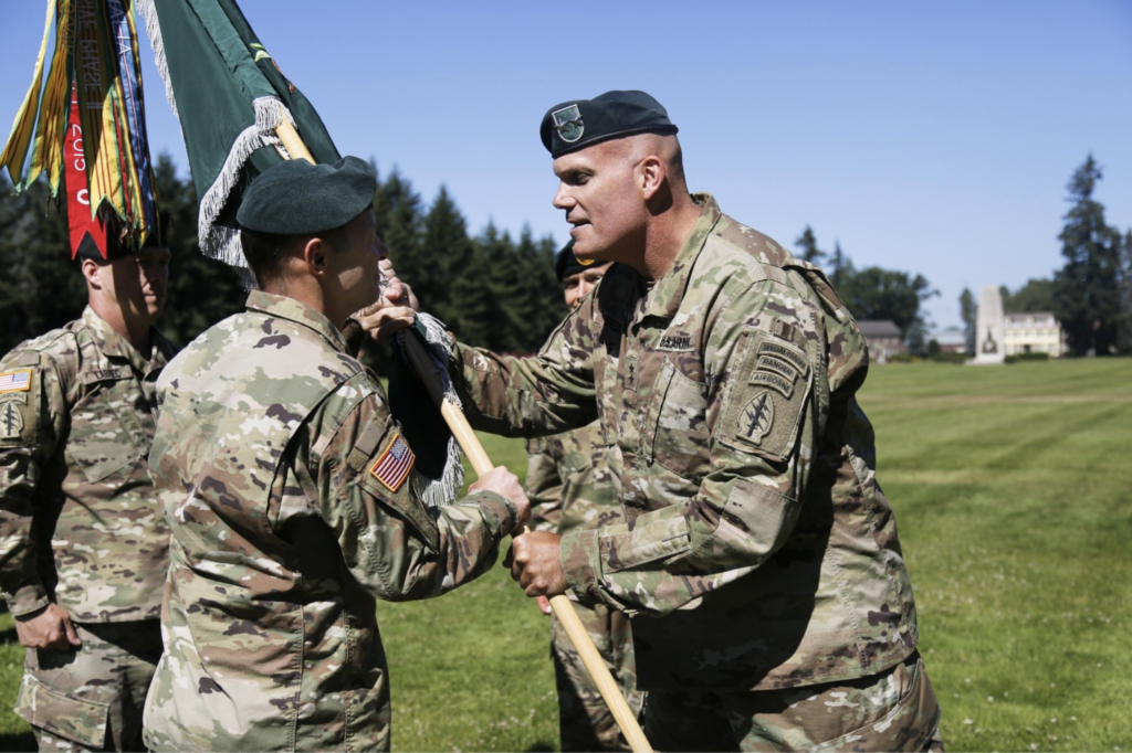 Maj. Gen. E. John Deedrick, Jr., the 1st Special Forces Command's commanding general passes the 1st Special Forces Group (Airborne) unit colors to Col. Owen G. Ray signaling the transfer of command from Col. Guillaume N. Beaurpere at Joint Base Lewis McChord, July 11, 2018. (U.S. Army)