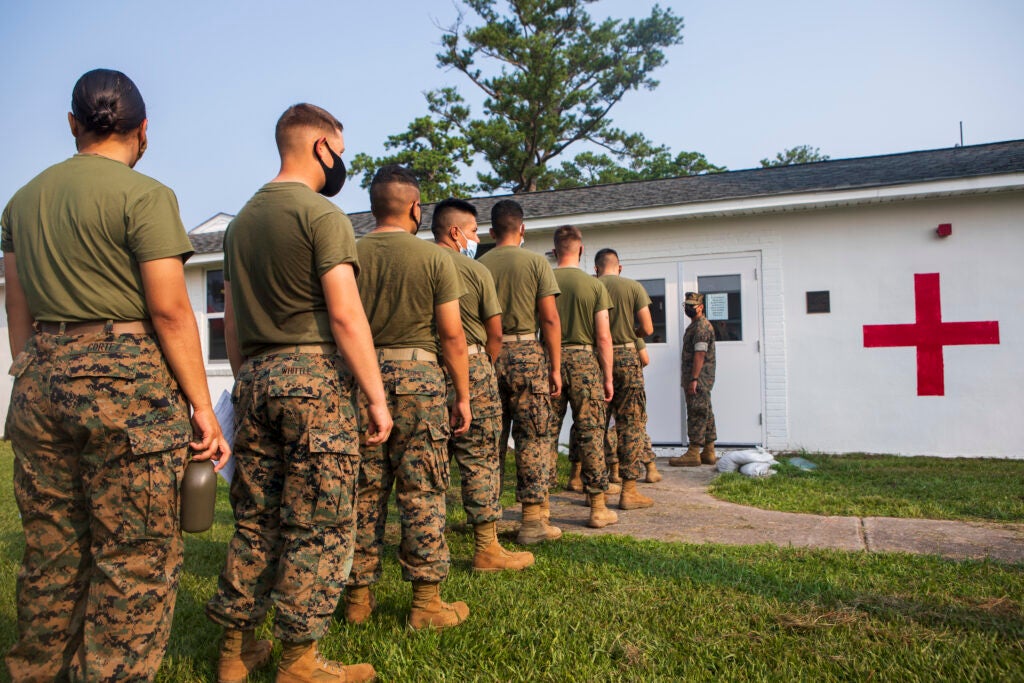 Entry-level Marines with Personnel Administration School, Marine Corps Combat Service Support Schools (MCCSSS), form a line for COVID-19 vaccinations at Camp Johnson, N.C., July 22, 2021.  Approximately 100 vaccinations were administered to MCCSSS entry-level Marines. (U.S. Marine Corps photo by Lance Cpl. Chandler Wilbourn)