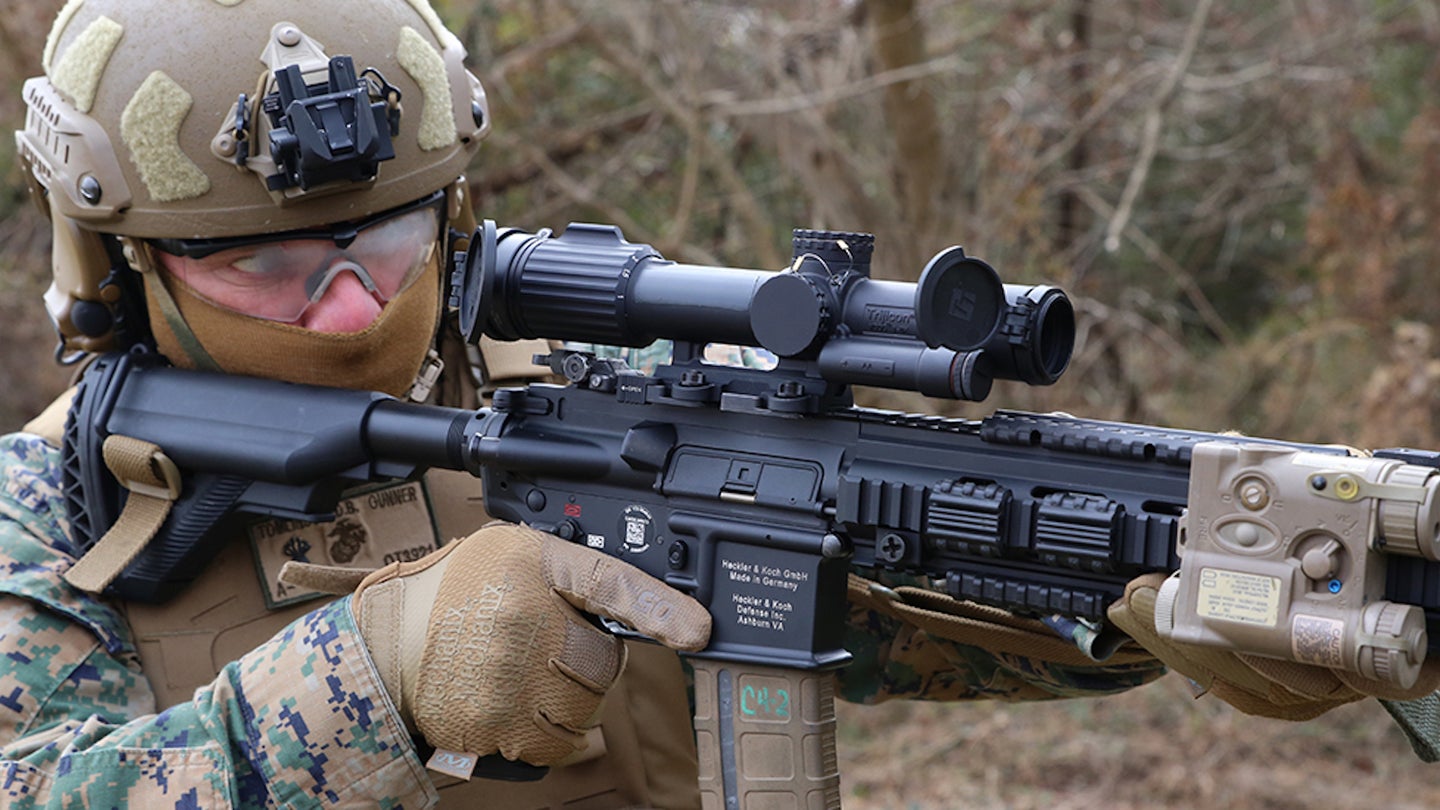 CWO4 Dave Tomlinson, infantry weapons officer at Marine Corps Systems Command, demonstrates the Squad Common Optic attached to the M27 Infantry Automatic Rifle, Feb. 10, 2021. 
