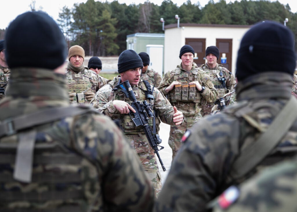 A Paratrooper assigned to the 82nd Airborne Division introduces himself to Polish Soldiers assigned to the 21st Rifle Brigade during a multi-national training event in Nowa Deba, Poland, Feb. 22, 2022. The focus of the 82nd Airborne Division's mission is to assure our Allies and partners and deter aggression as they have a host of unique capabilities and conduct a wide range of missions that are scalable and tailorable to mission requirements. (U.S. Army Photo by Master Sgt. Alexander Burnett)