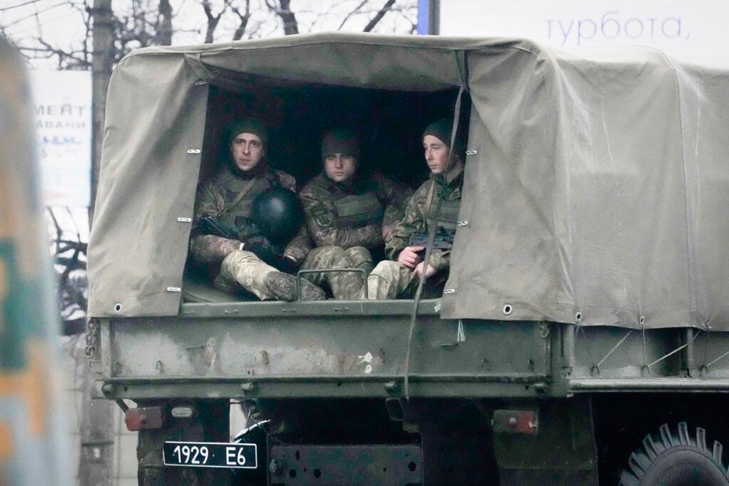 Ukrainian soldiers ride in a military vehicle in Mariupol, Ukraine, Thursday, Feb. 24, 2022. Russian troops launched their anticipated attack on Ukraine on Thursday, as President Vladimir Putin cast aside international condemnation and sanctions, warning other countries that any attempt to interfere would lead to “consequences you have never seen.” (AP Photo/Sergei Grits)