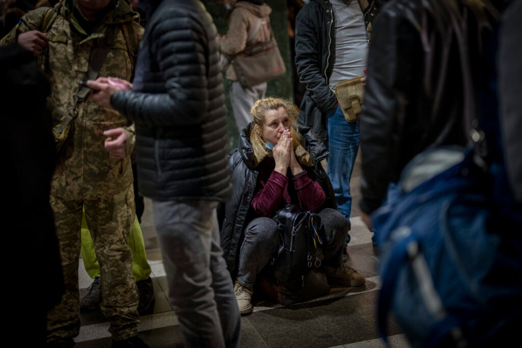 A woman reacts as she waits for a train trying to leave Kyiv, Ukraine, Thursday, Feb. 24, 2022. Russian troops have launched their anticipated attack on Ukraine. Big explosions were heard before dawn in Kyiv, Kharkiv and Odesa as world leaders decried the start of an Russian invasion that could cause massive casualties and topple Ukraine's democratically elected government. (AP Photo/Emilio Morenatti)