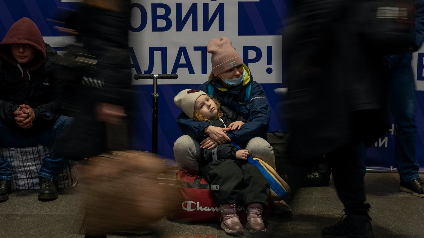 A woman with her daughter waits for a train as they try to leave at the Kyiv train station, Ukraine, Thursday, Feb. 24, 2022. (AP Photo/Emilio Morenatti)
